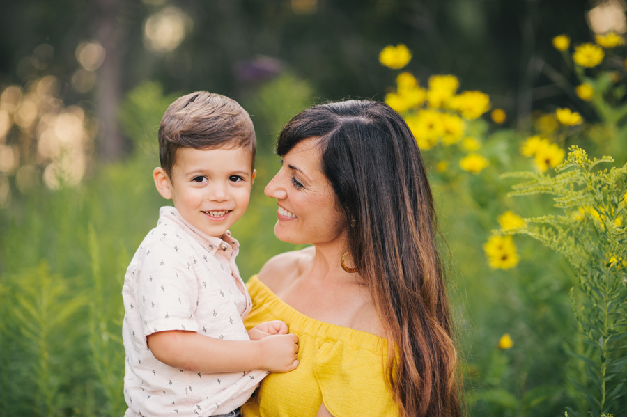 mom holding son who is smiling at camera