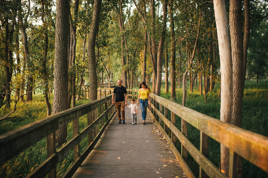 family holding hands and walking down a bridge towards camera